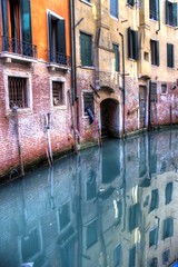 An empty canal in Venice, Italy with blue water.