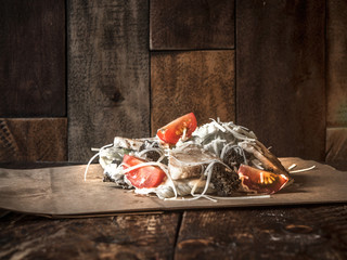 Delicious salad with in a cafe on a wooden background
