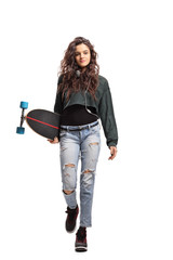 Teenage girl with a longboard walking towards the camera