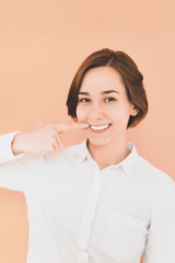 口を指差す若い女性（デンタルイメージ）