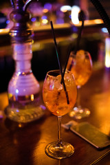Alcohol bar, cocktail glass on bar counter, cocktail glass in a bar, Drinking cocktail in bar, cocktail in the glass with straws, Fresh drink coctail on a color background