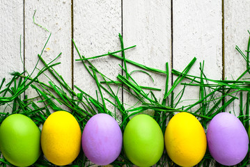 Happy easter eggs on wooden background, colorful eggs on white boards