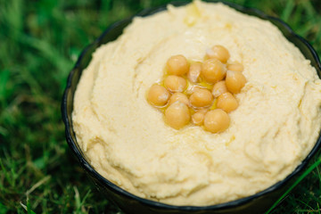 Traditional Middle east appetizer Hummus. Chickpea dip. Top view. Natural grass background.
