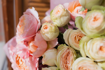 An amazing bouquet of diferent colourful flowers standing near the window.