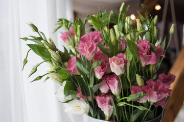 An amazing bouquet of diferent colourful flowers standing near the window.
