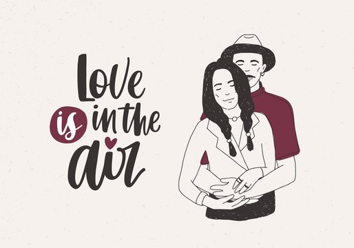 Man in hat standing behind woman with braids and embracing her and Love Is In The Air lettering on light background