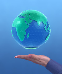 World Globe. 'Holographic' CG model of a globe above the facing up palm of a men's hand on blue background. Photo and 3D-render compositing.