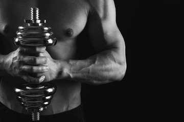 Fototapeta na wymiar Strong athletic man with dumbbell showes naked muscular body