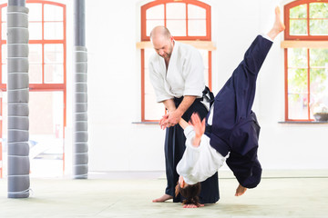 Fototapeta premium Man and woman fighting at Aikido training in martial arts school 