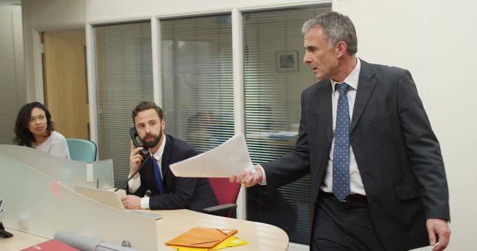 4K Aggressive business manager yelling at female employee & throwing papers. Realistic business concept of workplace issues