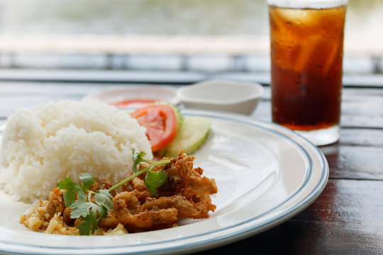 Fried Pork with garlic and pepper on rice with Cola in a glass