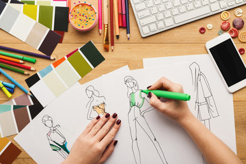 Fototapeta na wymiar Top view on woman designer drawing clothes sketches