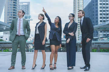 Professional business team looking forward confidently standing outdoors in cityscape background