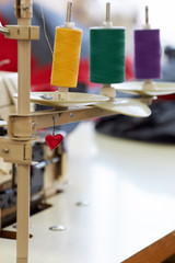 Closeup of coils with colored threads on sewing machine overlock.