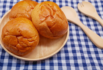 Breads on wooden plate close up with spoon and fork