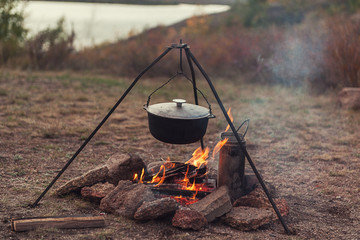 Preparing food on campfire in wild camping, resting on the nature