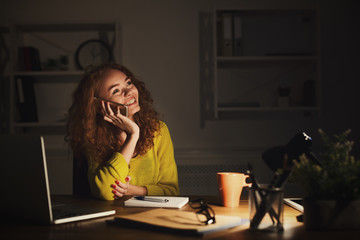 Smiling woman at work talking on phone
