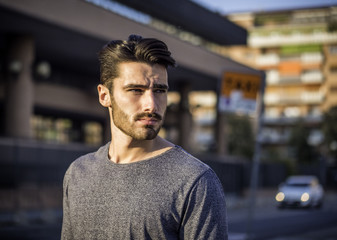 Attractive young bearded man portrait in urban environment