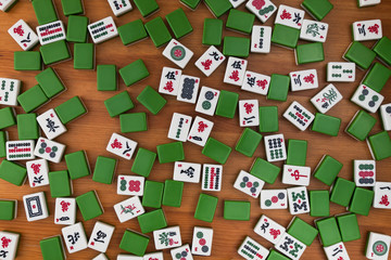 White-green tiles for mahjong on a brown wooden background. No empty place.