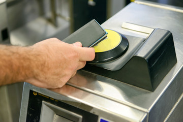 Man hand using card to enter city subway gate