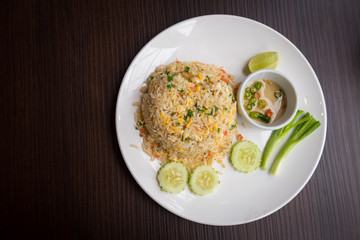 Crab meat fried rice with vegetables in dish on wooden table