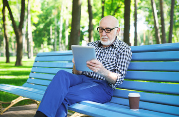 Fototapeta premium Senior man in casual with digital tablet outdoors