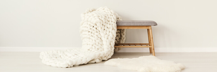 White knit blanket on stool