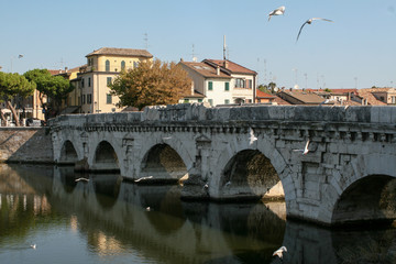 Fototapeta na wymiar Summer. Italy. Rimini. Bridge of Tiberius. Gulls on the bridge. Colorful