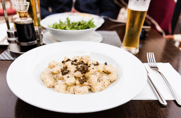 Potato gnocchi, Italian potato dumplings with truffle mushrooms and cheese sauce on a plate in a restaurant.