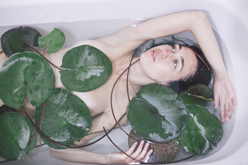 girl in a bath with lotus leaves