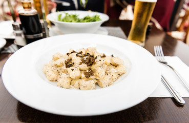 Potato gnocchi, Italian potato dumplings with truffle mushrooms and cheese sauce on a plate in a restaurant.