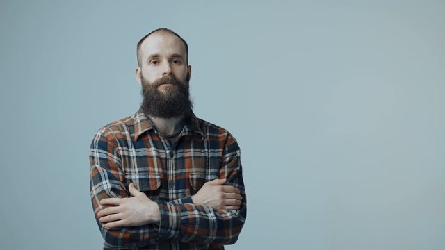 Confident hipster bearded man standing with folded hands