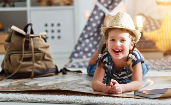 funny child girl tourist with world map, backpack and magnifier