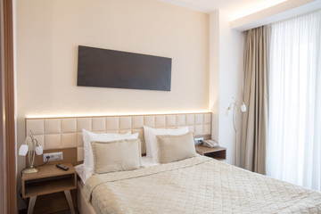 interior of  bright bedroom with  large bed and big window