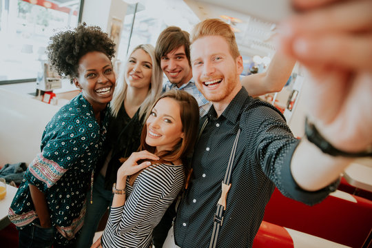 Group of young people taking selfie with mobile phone
