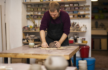 Skilled master preparing clay workpieces for new his creations