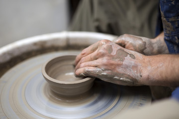 Artist makes clay pottery on a spin wheel