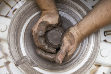 Fototapeta premium Artist makes clay pottery on a spin wheel