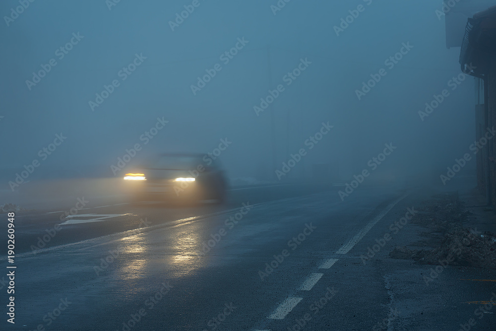 Wall mural car at night on wet and slippery foggy road