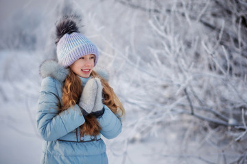 Fototapeta na wymiar Portrait of little girl in a winter forest