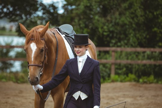 Female jockey leading her horse 