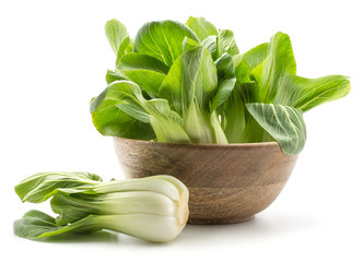 Fresh bok choy (Pak choi) in a wooden bowl one cabbage is near isolated on white background.