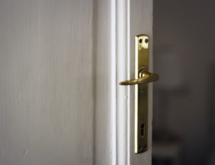 ncient handle of a door painted in white