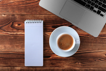 copybook, book and laptop. Cups of coffee on the table