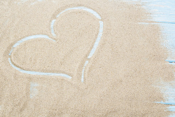 Heart background drawn on the sand of a beach, love background valentine day with happy holiday, or wedding vintage wallpaper, woman or mother day concept romantic design postcard in beach sand.