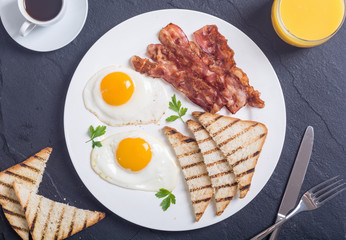 Breakfast with eggs bacon and toasts