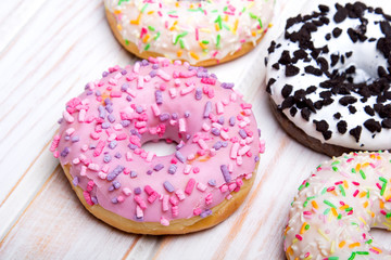 Traditional donuts on white wooden background.  Tasty doughnuts with icing, copy space