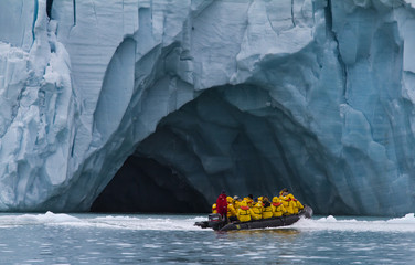 tourists traveling in a small zodiac boat in archipelago of  Svalbard - obrazy, fototapety, plakaty