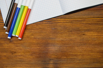 Study. colored markers and notebook on wooden background
