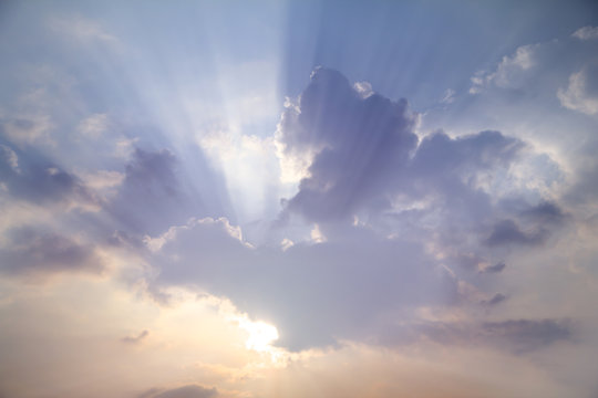 Fototapeta Sun shines through white clouds caused rays of light on hazy day blue sky 